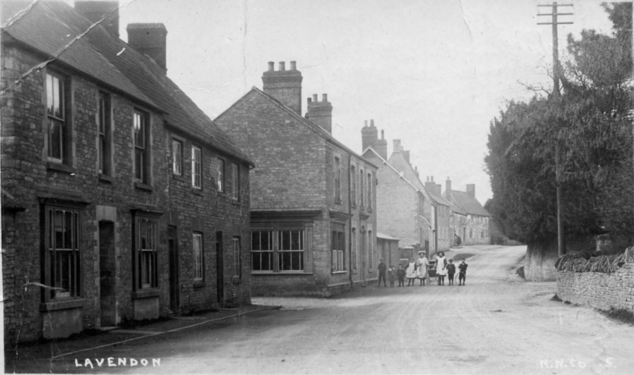 Northampton Road, Lavendon, with the former butcher's shop to the left of the pedestrians.